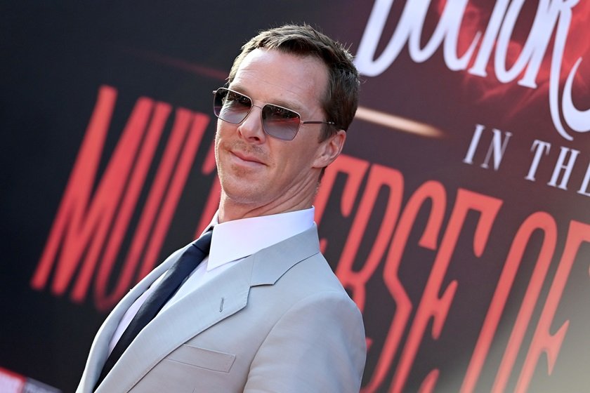 Benedict Cumberbatch está usando um terno cinza claro e óculos escuro - Metrópoles