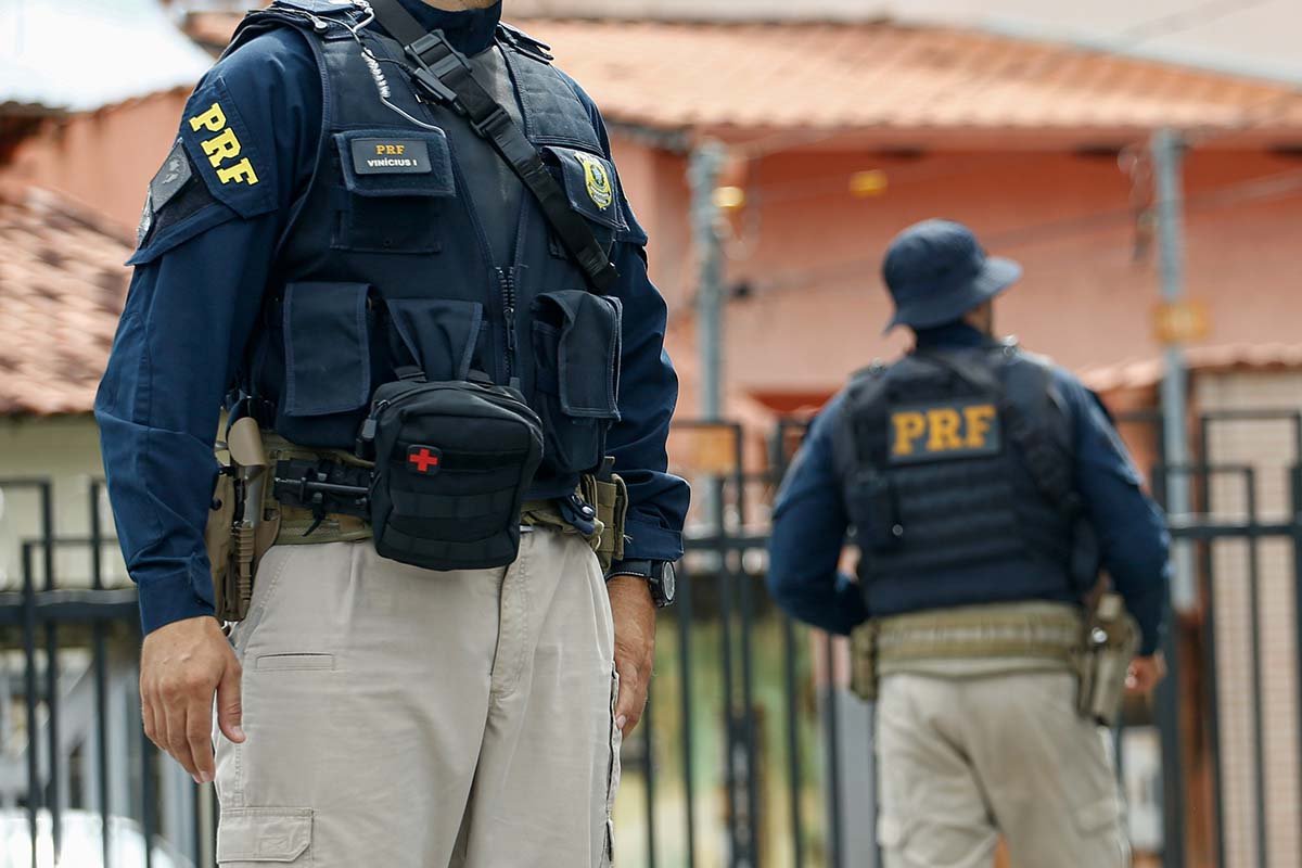 Um Cara De Uniforme Policial Com Uma Espingarda De Atirador