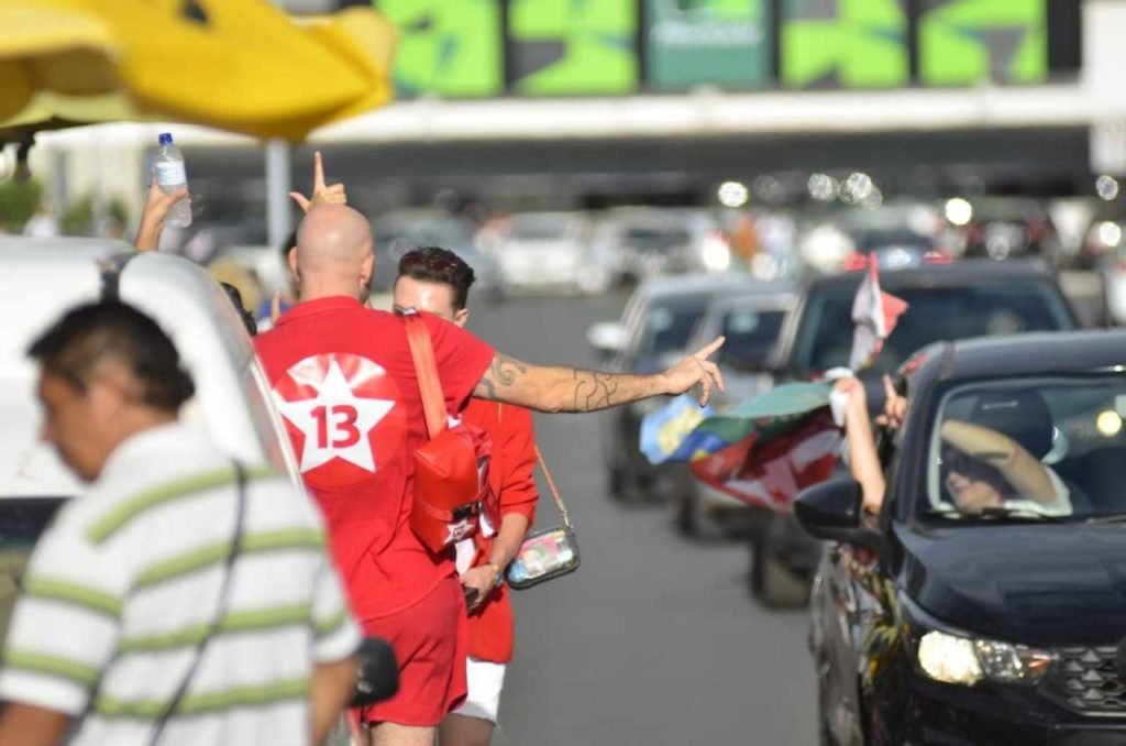 homem branco com camisa vermelha com o número 13 estampado nas costas