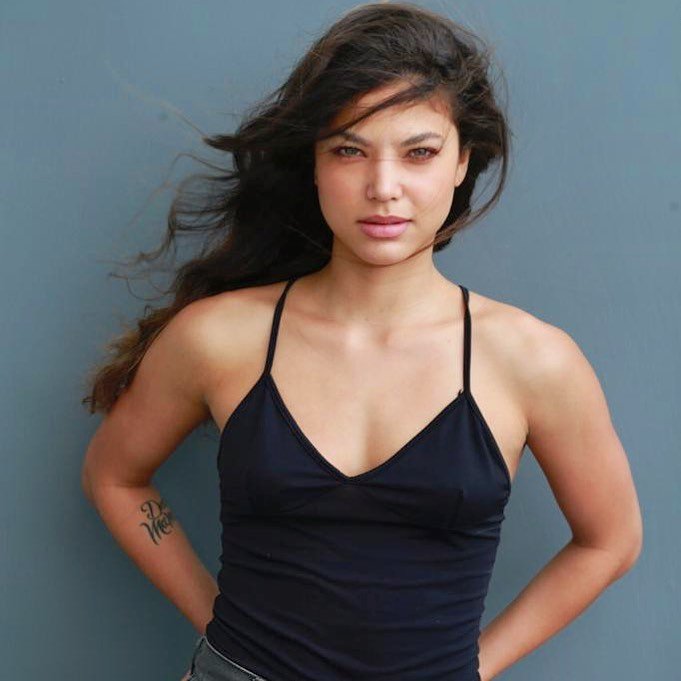 Foto colorida da atriz Heloísa Honein usando blusa preta com as mãos para trás - Metrópoles