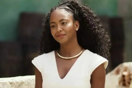 Foto colorida de Laura, personagem da novela Mar do Sertão, vestida de branco e usando um colar da mesma cor - Metrópoles