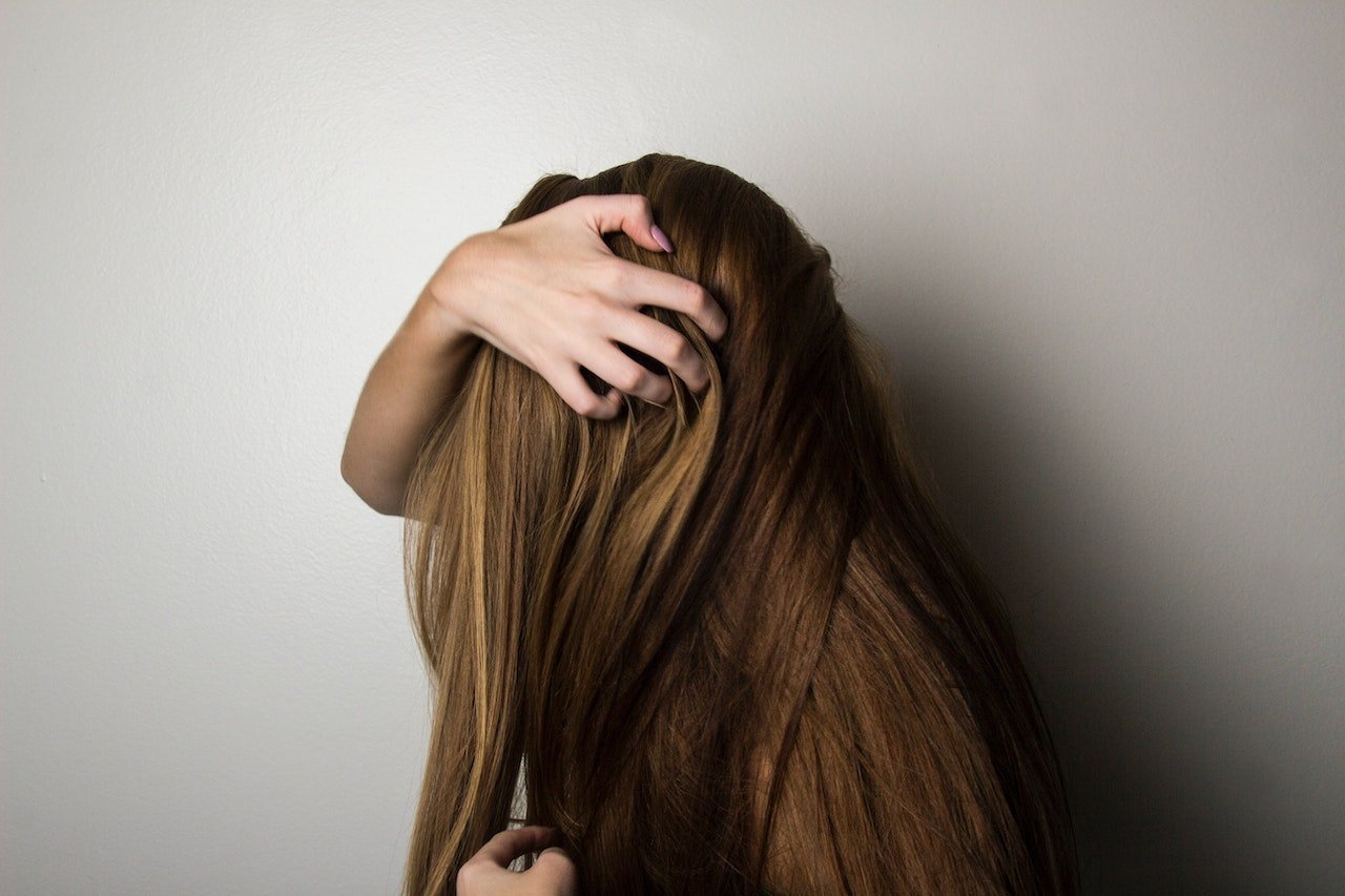 mulher passando a mão no cabelo - Metrópoles
