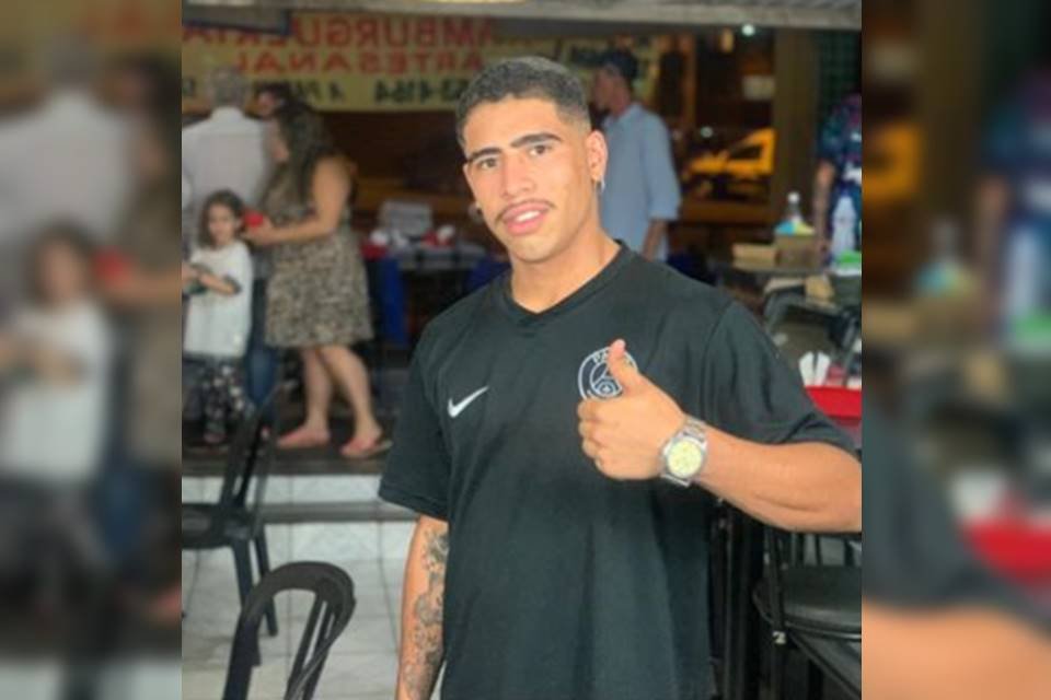 Homem de camiseta preta fazendo símbolo de beleza com as mãos - Metrópoles