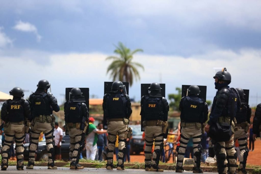 Policiais rodovirios federais formam barreira com escudos e fortemente equipados para desocurpar bloqueio em rodovia por apoiadores bolsonaristas. Eles so vistos de costas na cidade goiana de Luzinia - Metrpoles