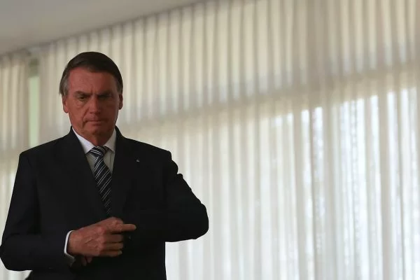 O presidente da República, Jair Messias Bolsonaro (PL) caminha pelo Palácio do Planalto. Ele arruma seu terno, olhando para baixo - Metrópoles