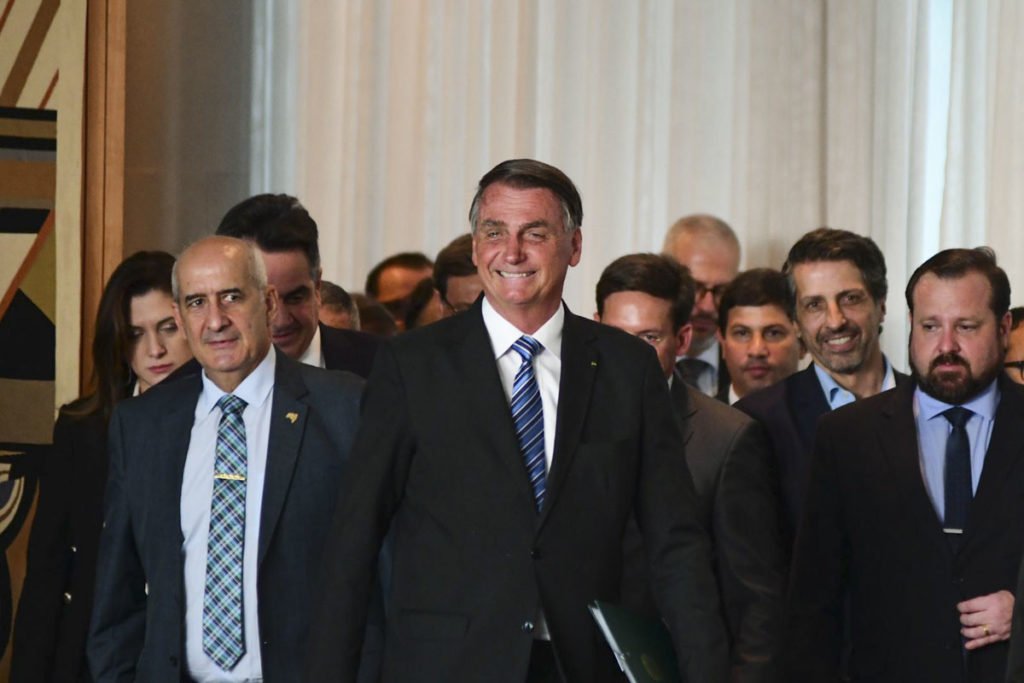 Cercado por ministros e aliados, Jair Bolsonaro caminha sorrindo para fazer o pronunciamento aos brasileiros após derrota nas eleições, no Palácio do Planalto - Metrópoles - Metrópoles