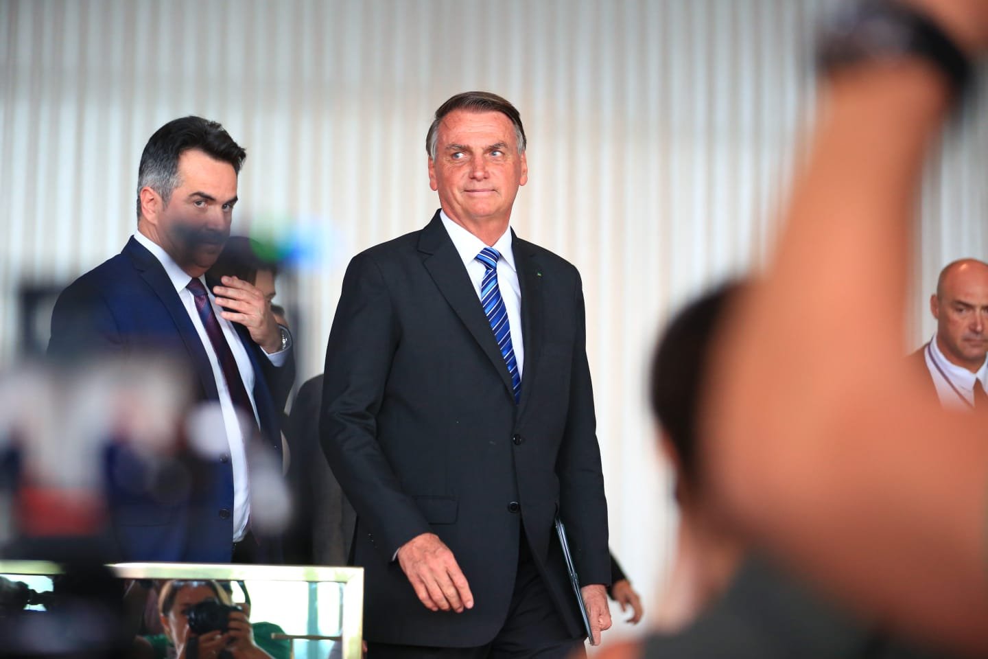 Imagem colorida mostra cercado por ministros e aliados, Jair Bolsonaro caminha de perfil para fazer o pronunciamento aos brasileiros após derrota nas eleições, no Palácio do Planalto - Metrópoles