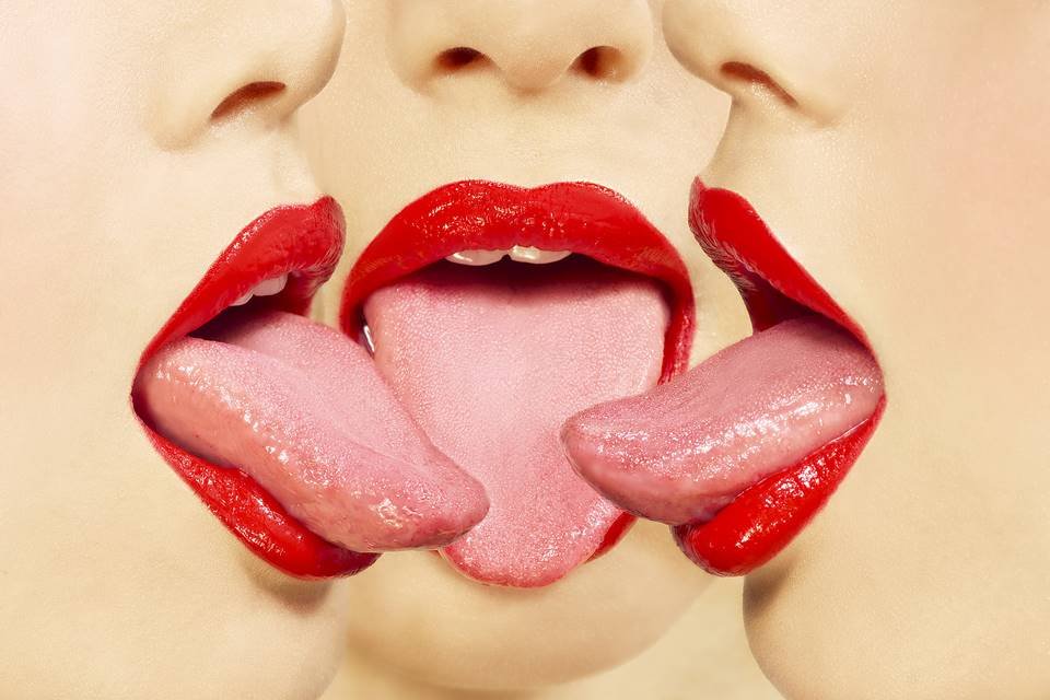 Três pessoas de batom vermelho com a língua de fora - Metrópoles