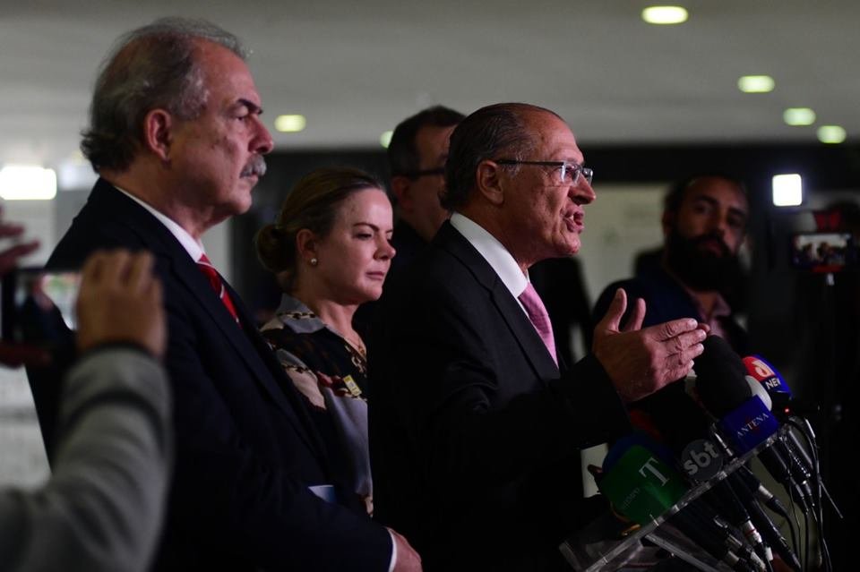 O coordenador da equipe de transição de Lula e vice-presidente eleito, Geraldo Alckmin, dá entrevista diante de púlpito no Senado cercado de outros políticos - Metrópoles