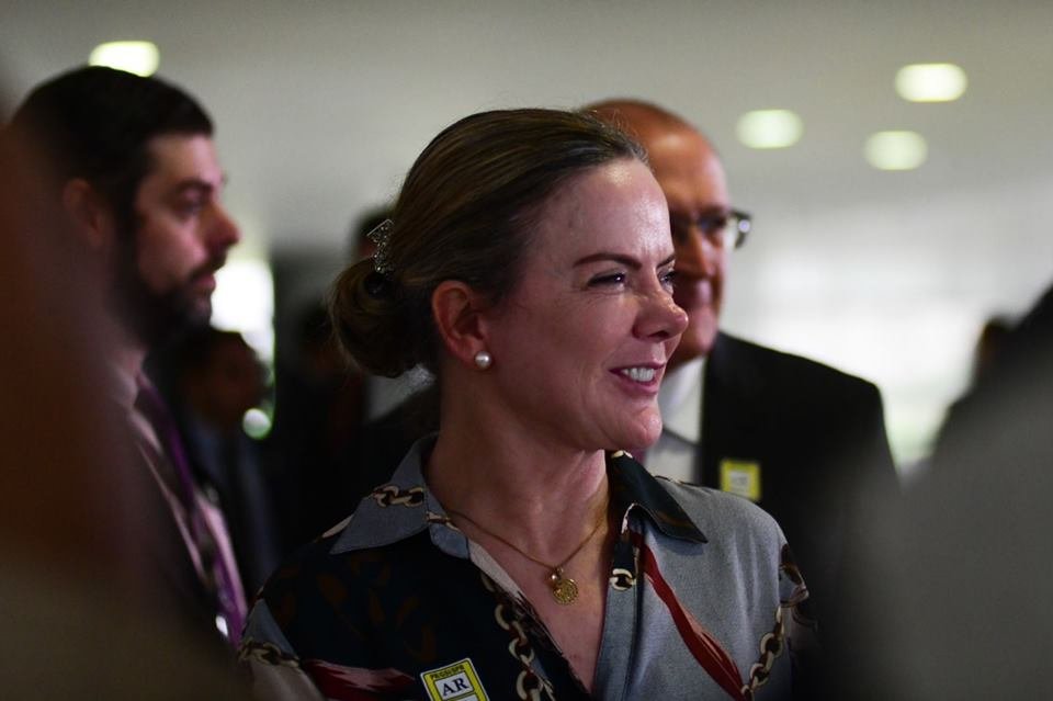 Integrante da equipe de transição do presidente eleito Lula, Gleisi Hoffman, sorri ao lado do coordenador e vice-presidente eleito, Geraldo Alckmin, cercados de outros políticos - Metrópoles