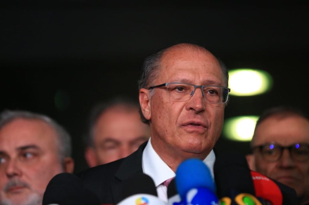 O coordenador da equipe de transição de Lula e vice-presidente eleito, Geraldo Alckmin, dá entrevista diante de púlpito no Senado cercado de outros políticos e imprensa - Metrópoles