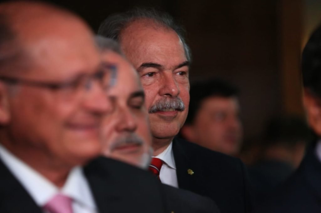 Aloizio Mercadant acompanha a coletiva com Geraldo alckmin diante de púlpito no Senado cercado de outros políticos - Metrópoles