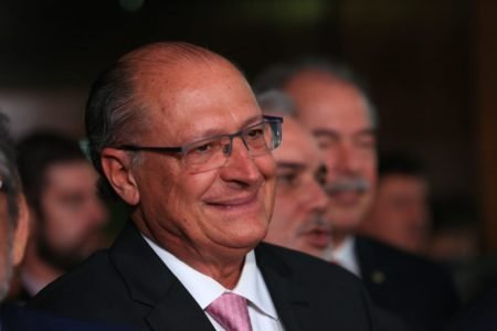 O coordenador da equipe de transição de Lula e vice-presidente eleito, Geraldo Alckmin, dá entrevista diante de púlpito no Senado cercado de outros políticos - Metrópoles