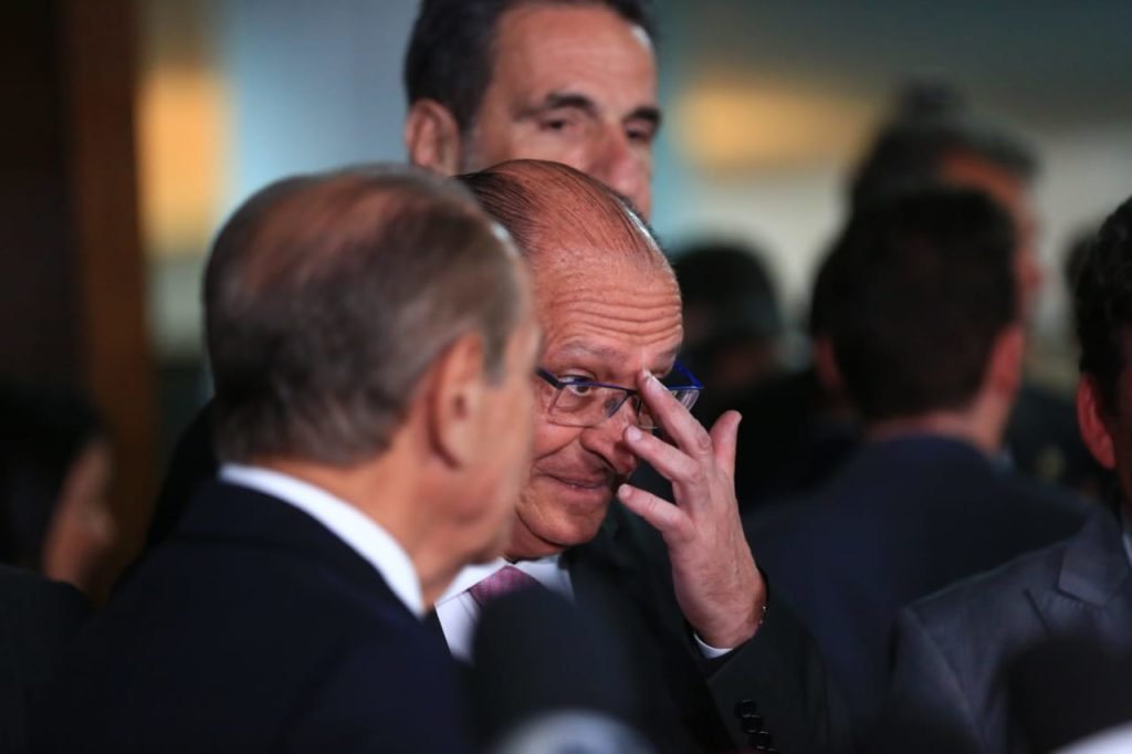 O coordenador da equipe de transição de Lula e vice-presidente eleito, Geraldo Alckmin, dá entrevista diante de púlpito no Senado cercado de outros políticos - Metrópoles