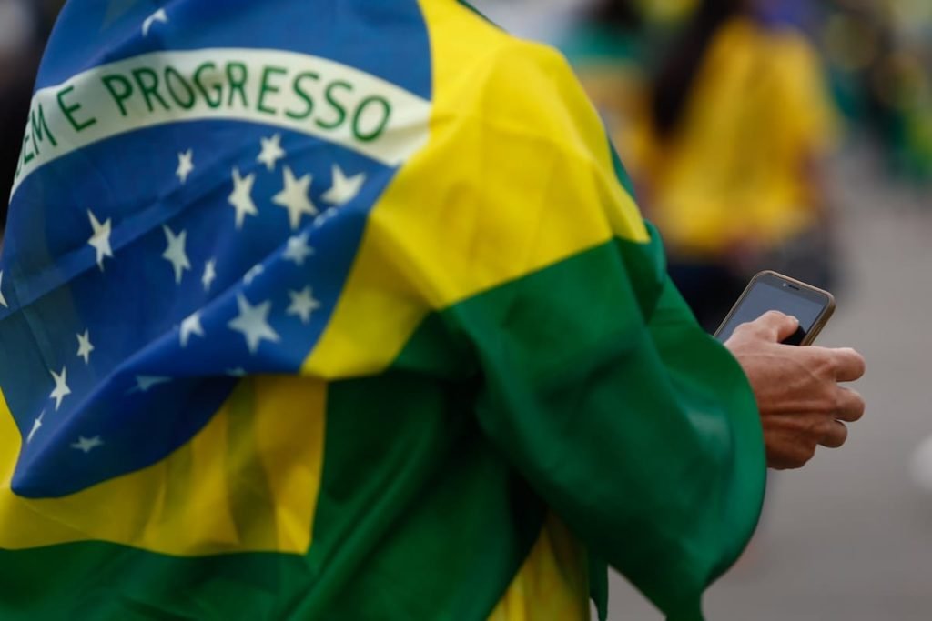 Manifestantes pró-Bolsonaro com o celular na mão durante ato no QG do Exército - Metrópoles