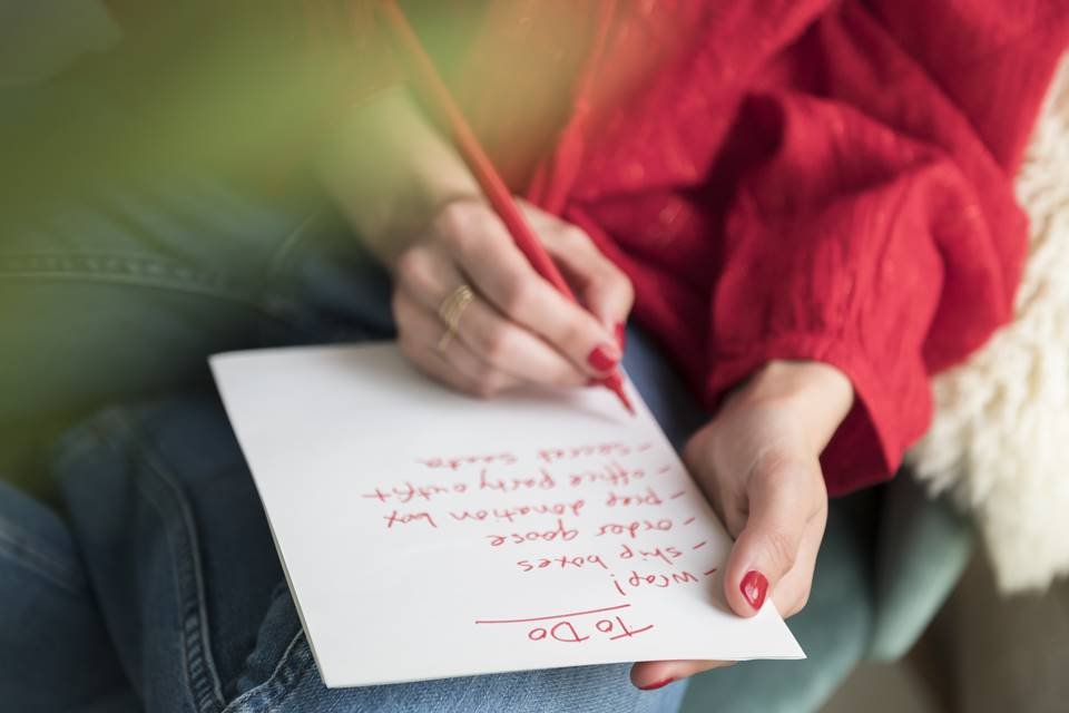 Mulher com lista de papel e caneta vermelha na mão - Metrópoles
