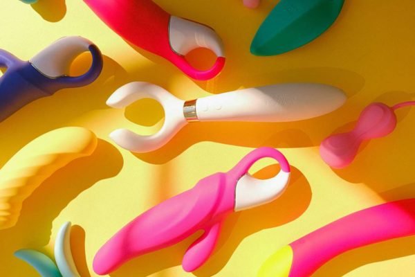 Vários sex toys espalhados em fundo amarelo - Metrópoles