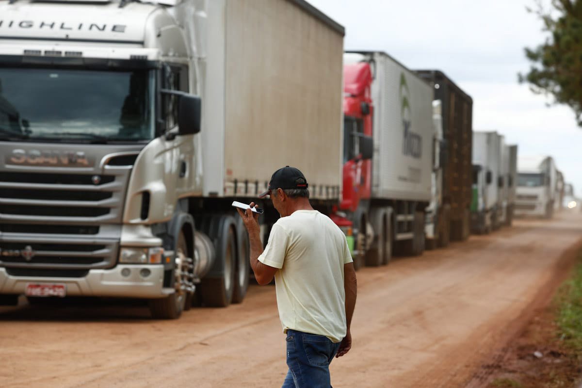 Caminhoneiro ouve a�dio em celular enquanto caminha por beira de rodovia onde se v� v�rios caminhos parados por conta de bloqueios realizados por apoiadores do presidente derrotado nas elei��es, Jair Bolsonaro - Metr�poles