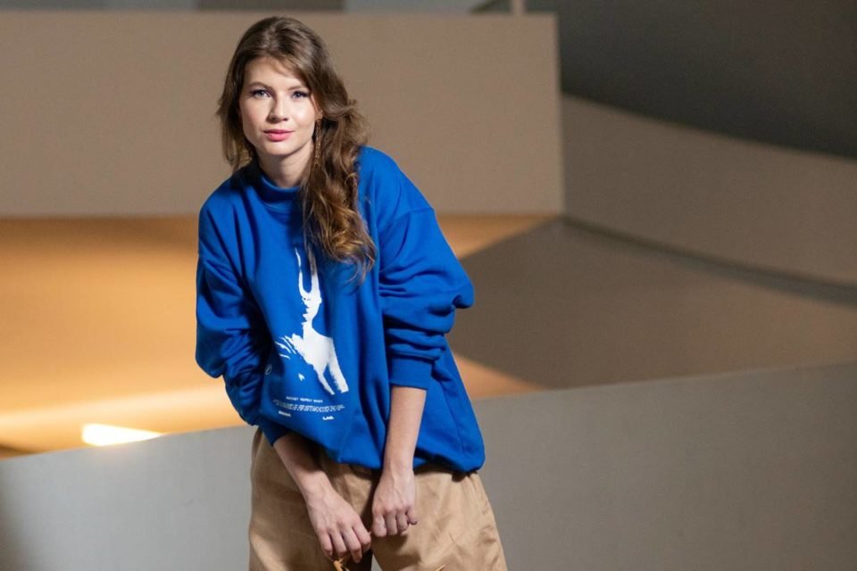 Modelo usa moletom na cor azul com estampa branca da marca Sinna Lab - Metrópoles