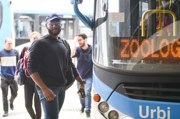 Foto de um homem ao lado de um ônibus