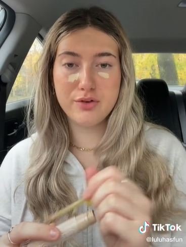 Foto colorida de menina loira se maquiando