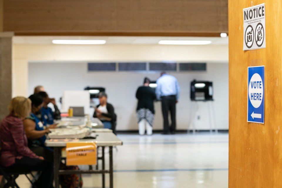 Pessoas de costas e sentadas em cadeiras votam para as eleições do Congresso dos EUA - Metrópoles