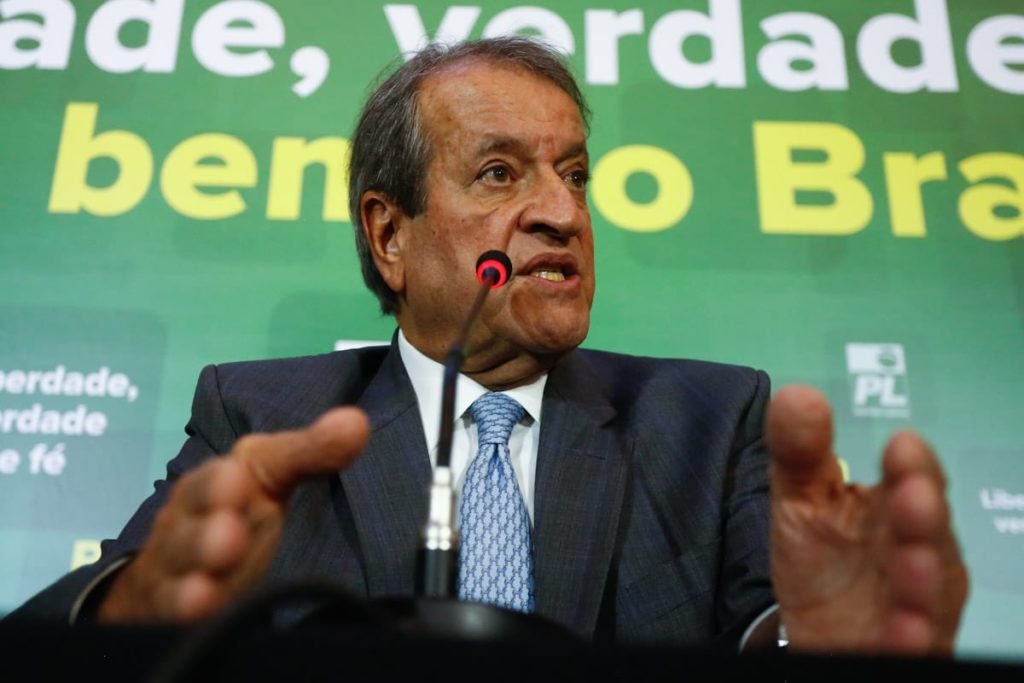 Presidente do PL, Valdemar Costa Neto declara oposição do PL ao governo do presidente eleito Lula durante coletiva de imprnesa. Ele fala em microfone, gesticulando e com painel atrás nas cores verde e amarelo - Metrópoles