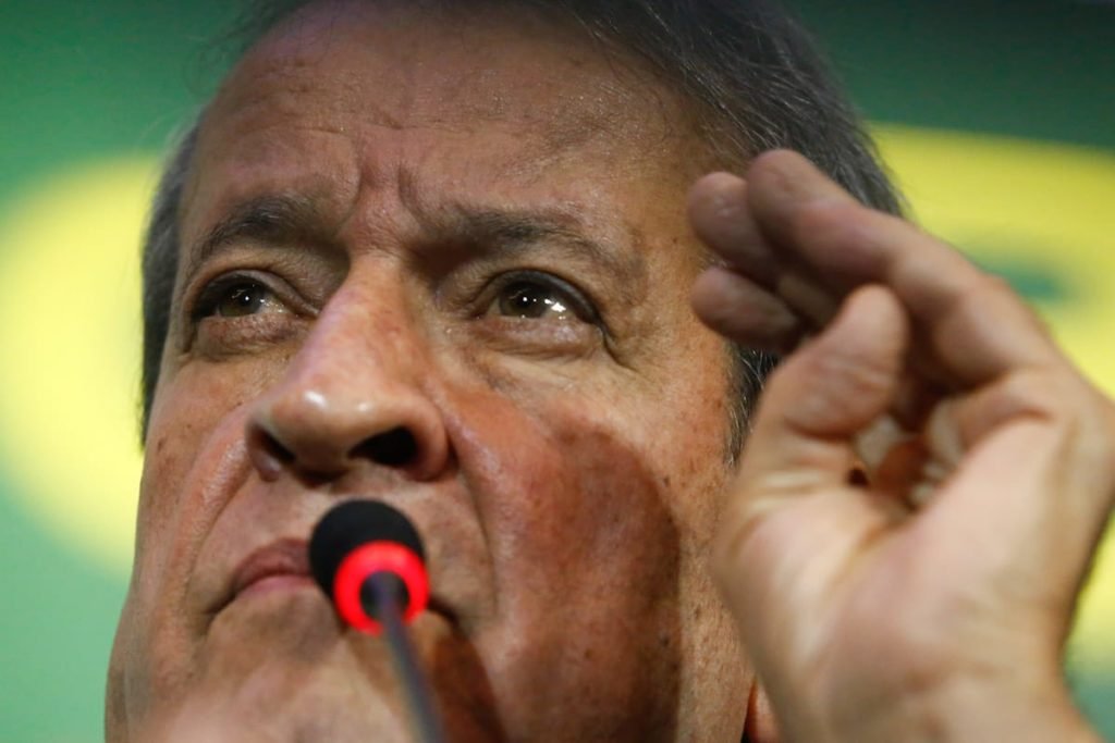 Presidente do PL, Valdemar Costa Neto declara oposição do PL ao governo do presidente eleito Lula durante coletiva de imprnesa. Ele fala em microfone, gesticulando e com painel atrás nas cores verde e amarelo - Metrópoles