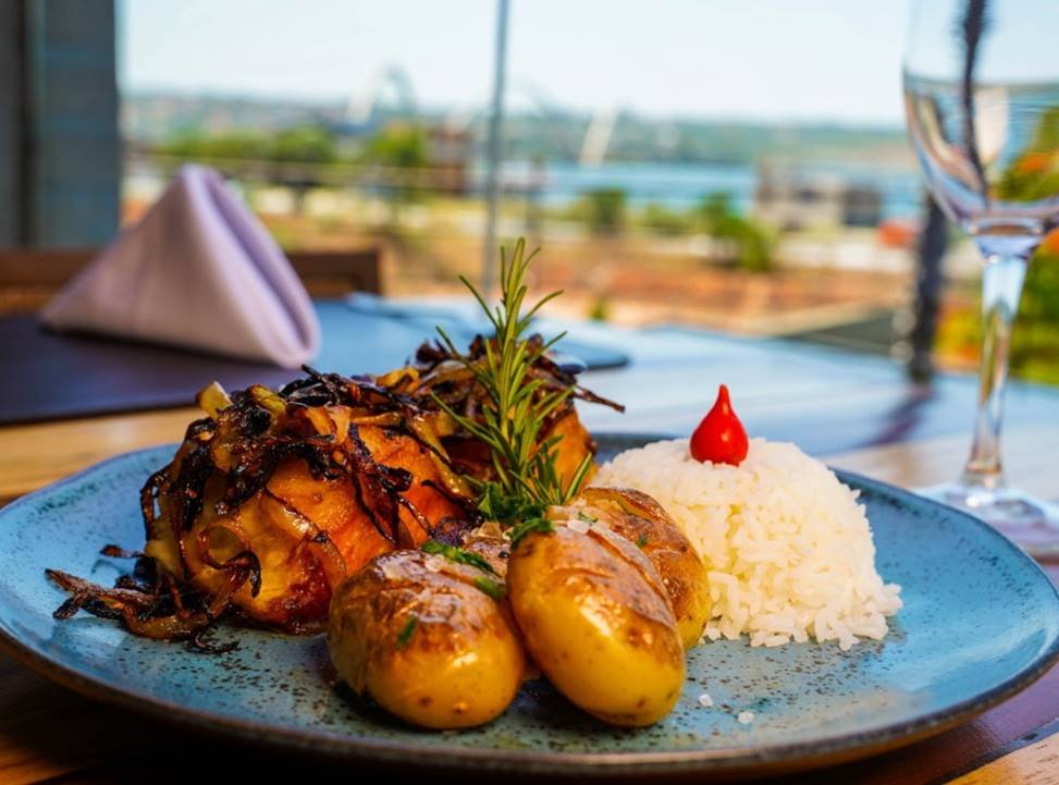 Foto de um prato com arroz e batatas grelhadas, com tradicional carne portuguesa