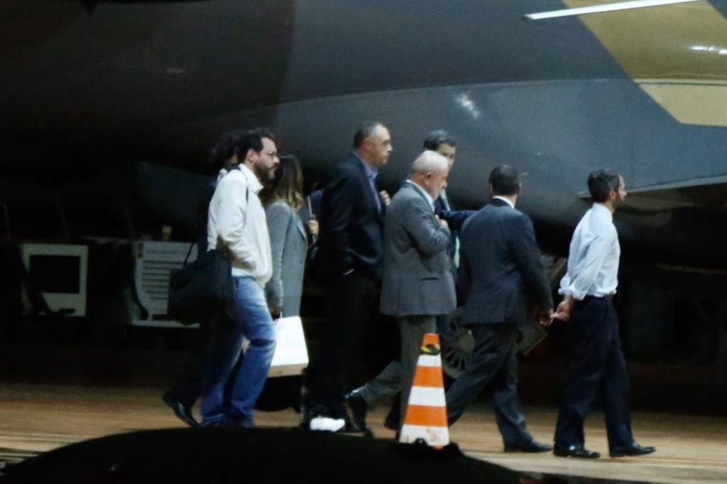 Foto colorida mostra o presidente eleito Luiz Inácio Lula da Silva (PT) e um grupo de pessoas andando por aeroporto em Brasília. / Metrópoles