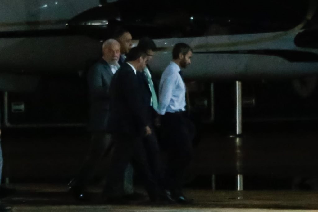 Foto colorida mostra o presidente eleito Luiz Inácio Lula da Silva (PT) e um grupo de pessoas andando por aeroporto em Brasília. / Metrópoles