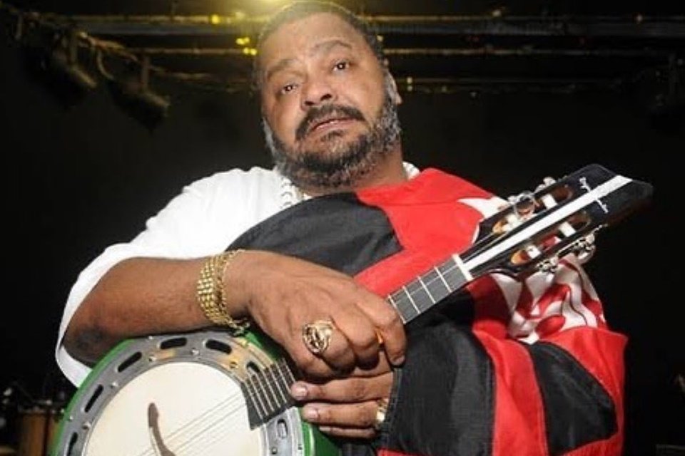 Imagem de Arlindo Cruz com um banjo e uma bandeira do Flamengo