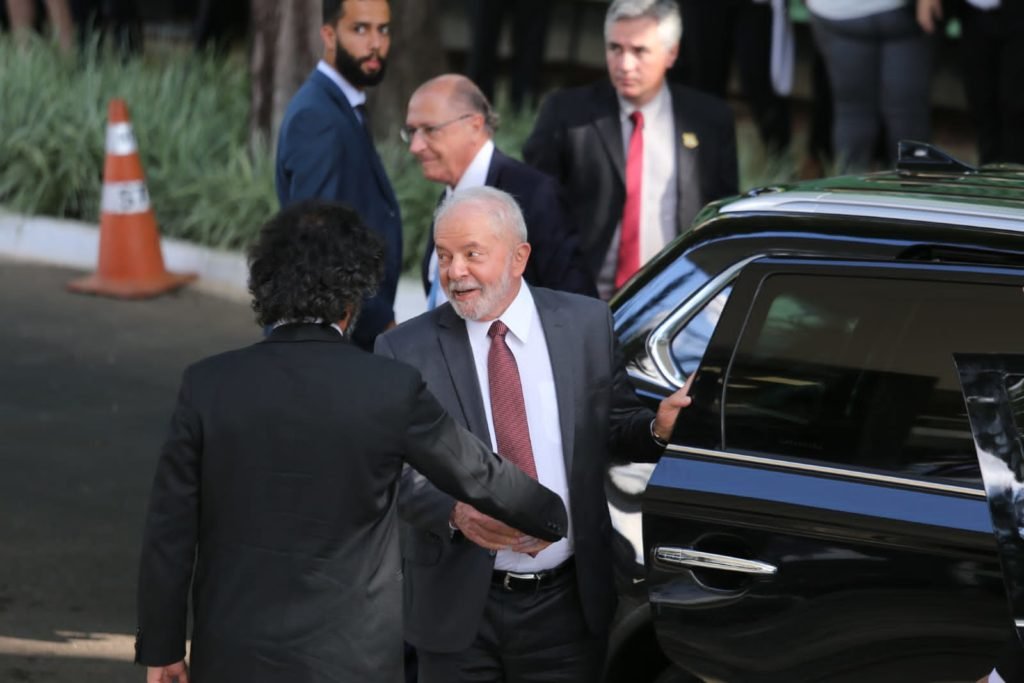 Presidente eleito Luiz Inácio Lula da Silva chega ao STF para reunião com a Ministra Rosa Weber em Brasília. Na foto, ele sorri ao descer do carro, ao lado de um homem - Metrópoles
