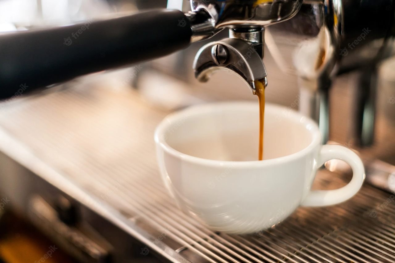 En la foto, una taza blanca en una máquina de café, que hace espresso - Metrópoles