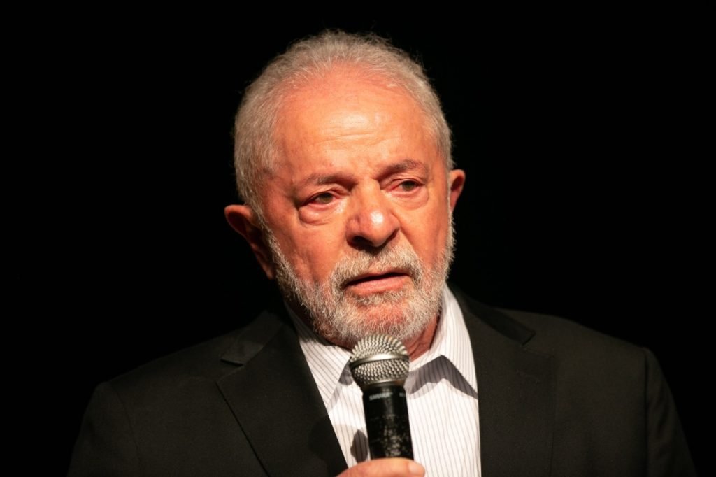 Imagem colorida mostra Luiz Inácio Lula da Silva, presidente eleito, em pé em um palco. Ele usa terno e segura um microfone - Metrópoles