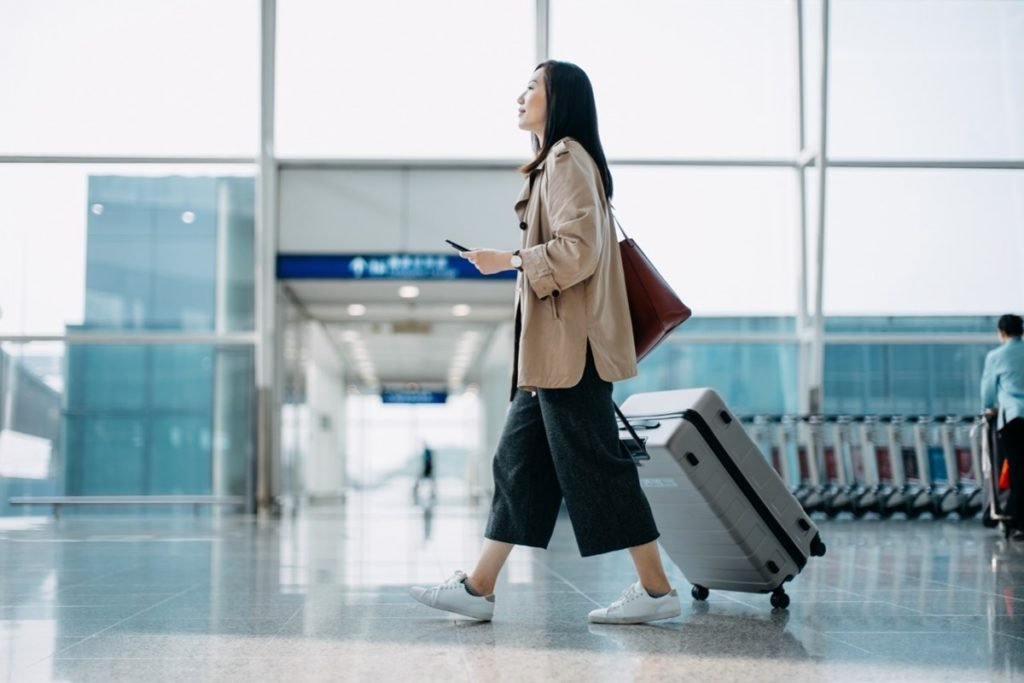Foto colorida de mulher andando em aeroportos. Passagens aéreas-Metrópoles