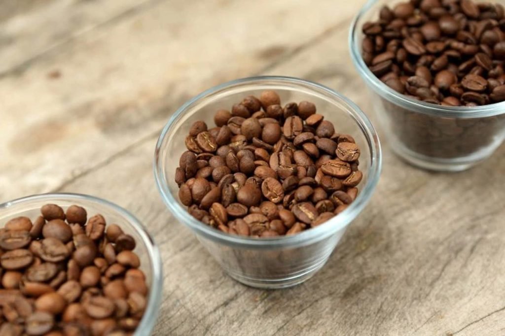 Três potes de vidro com grãoes de café de diferentes tonalidades - Metrópoles