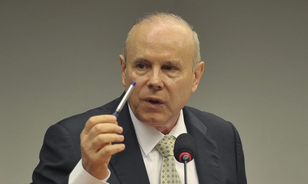 Guido Mantega com caneta na mão / Metrópoles