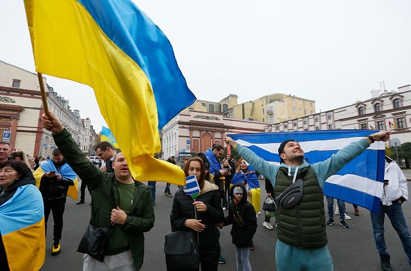 pessoas comemorando com bandeiras da ucrânia - metrópoles