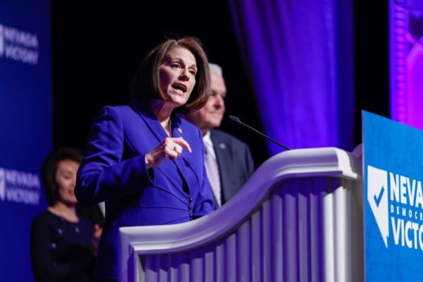 Senadora Catherine Cortez Masto, dos democratas, faz discurso em um p&uacute;lpito roxo. Ela veste um blazer tamb&eacute;m roxo - Metr&oacute;poles