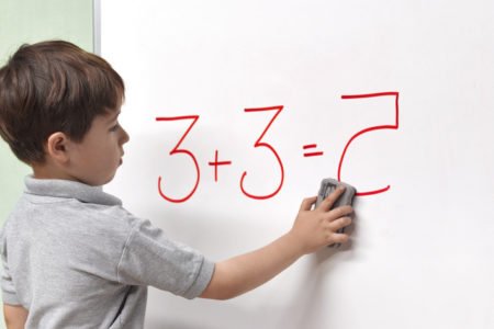 imagem de criança com dislexia escrevendo número espelhado