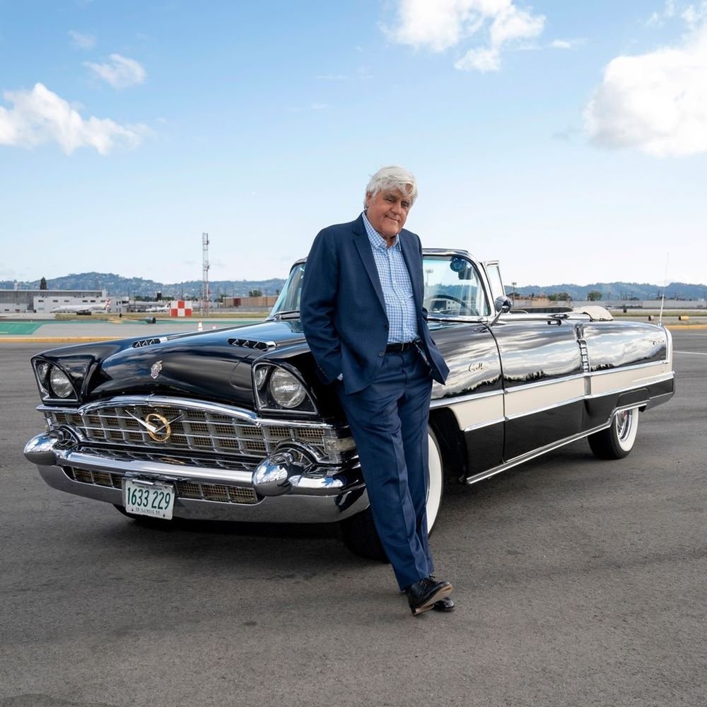 Jay Leno posa para foto ao lado de um de seus carros - Metrópoles