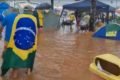 Bolsonaristas em meio a um acampamento alagado - Metrópoles