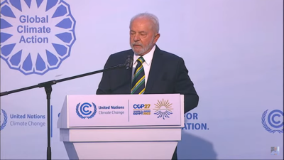 O presidente eleito Lula discursa em púlpito na COP27, no Egito. Ele fala diante de microfone - Metrópoles