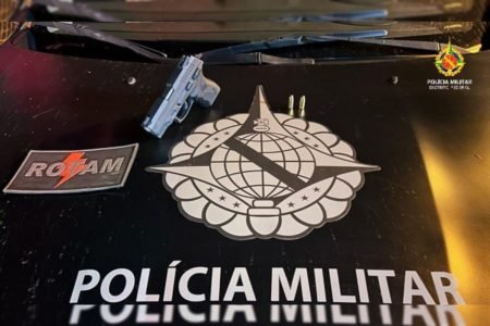Arma de fogo em cima de capô de viatura da Polícia Militar do DF (PMDF)