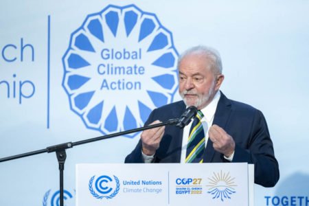 O presidente eleito Lula discursa em púlpito na COP27, no Egito. Ele fala diante de microfone - Metrópoles