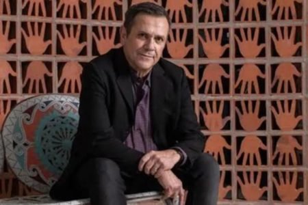 homem de terno sentado posa sério - Metrópoles