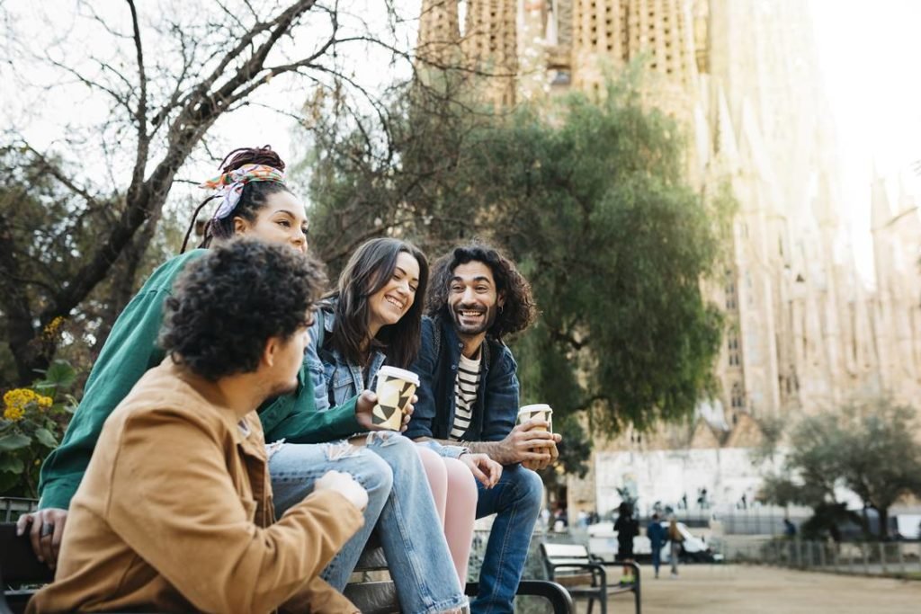 Cinco pessoas sentadas e vestido roupas de frio enquanto conversam e tomam café