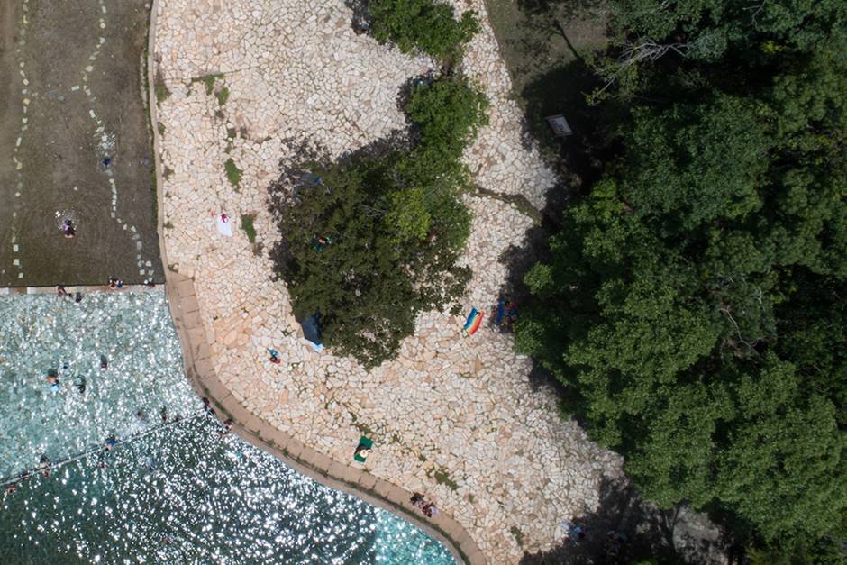 árvores, chão de pedras e piscina vistos de cima