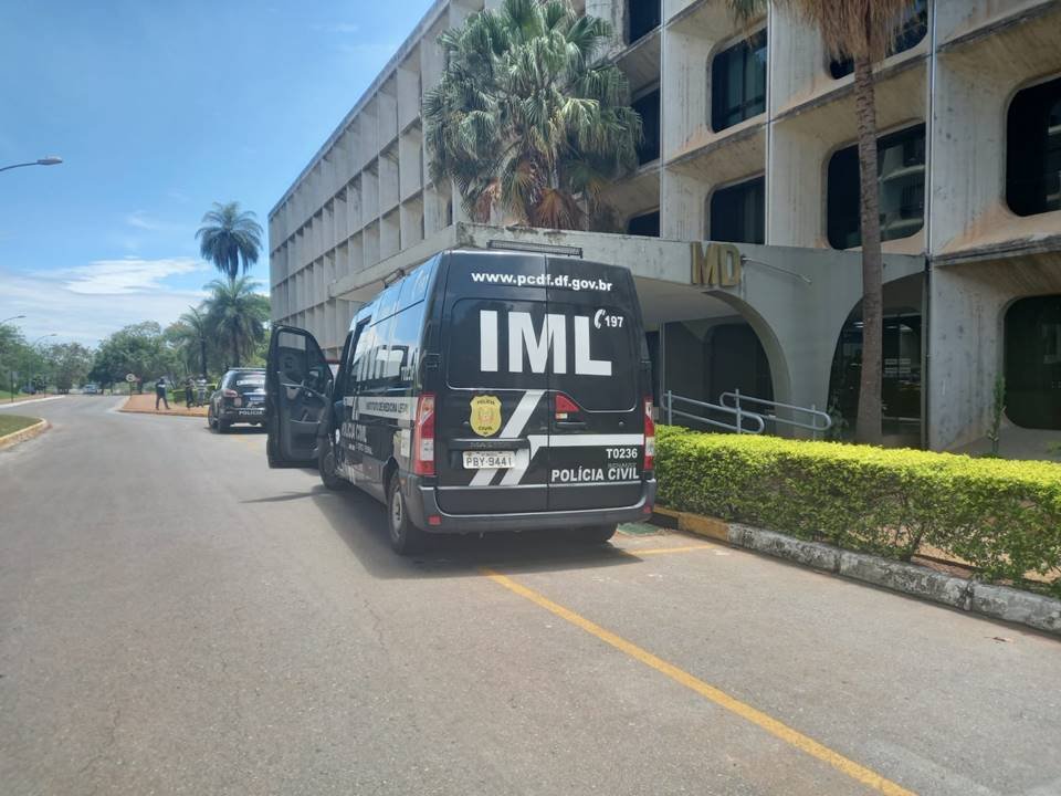 Ministério da Defesa com carro do IML parado à porta